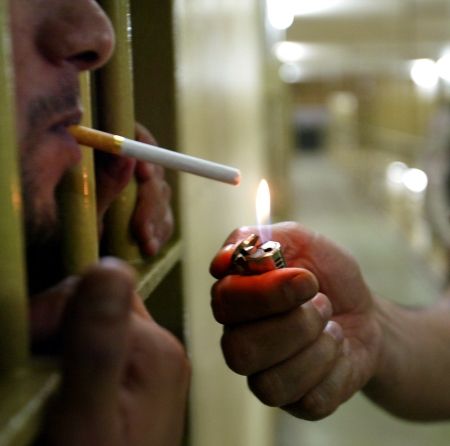 Un criminal scoate fumatul din celulă cu justiţia