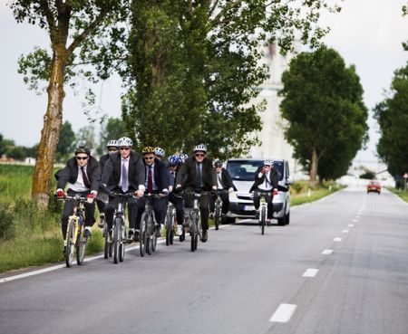 În costum, pe bicicletă, pentru copiii săraci