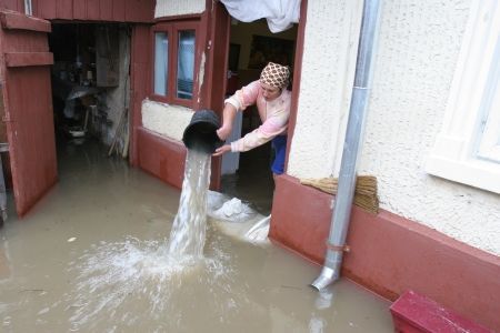 Ploile au lăsat în urmă case distruse şi drumuri blocate