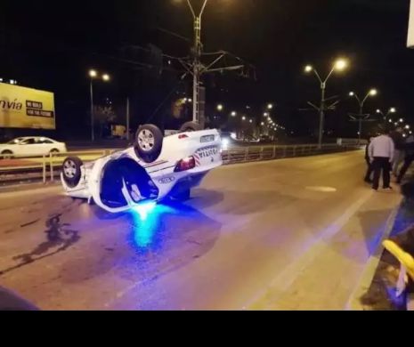 Mașina de poliție răsturnată în București. Polițiștii au fost duși la spital