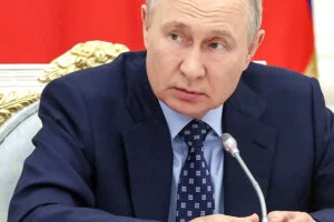 Vladimir Putin stă cu mâna pe un butoi cu pulbere