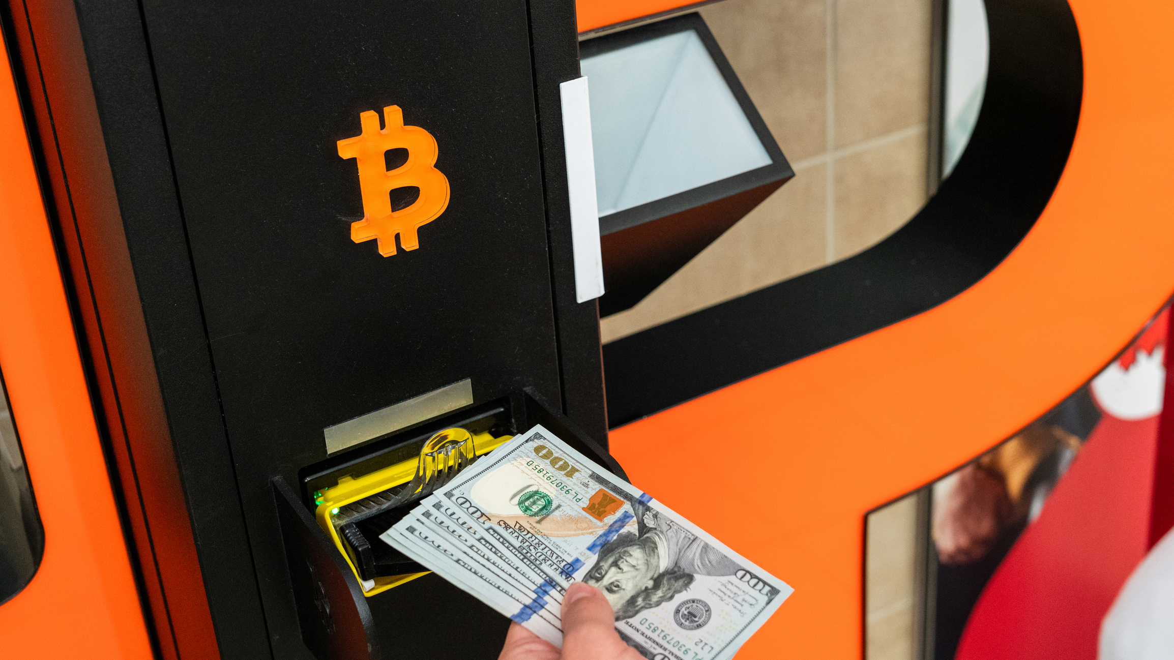 Dolari extrași dintr-un ATM de bitcoini. Utilizatorii pot schimba criptomonedele în valută. Sursa Foto- Dreamstime 