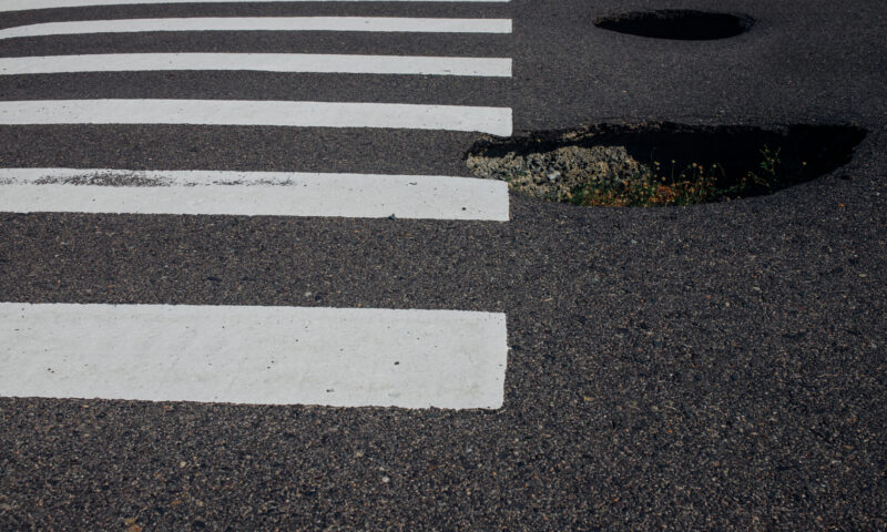 S-a surpat asflatul sub ei! Două persoane au ajuns la spital după ce au căzut în groapa de pe stradă